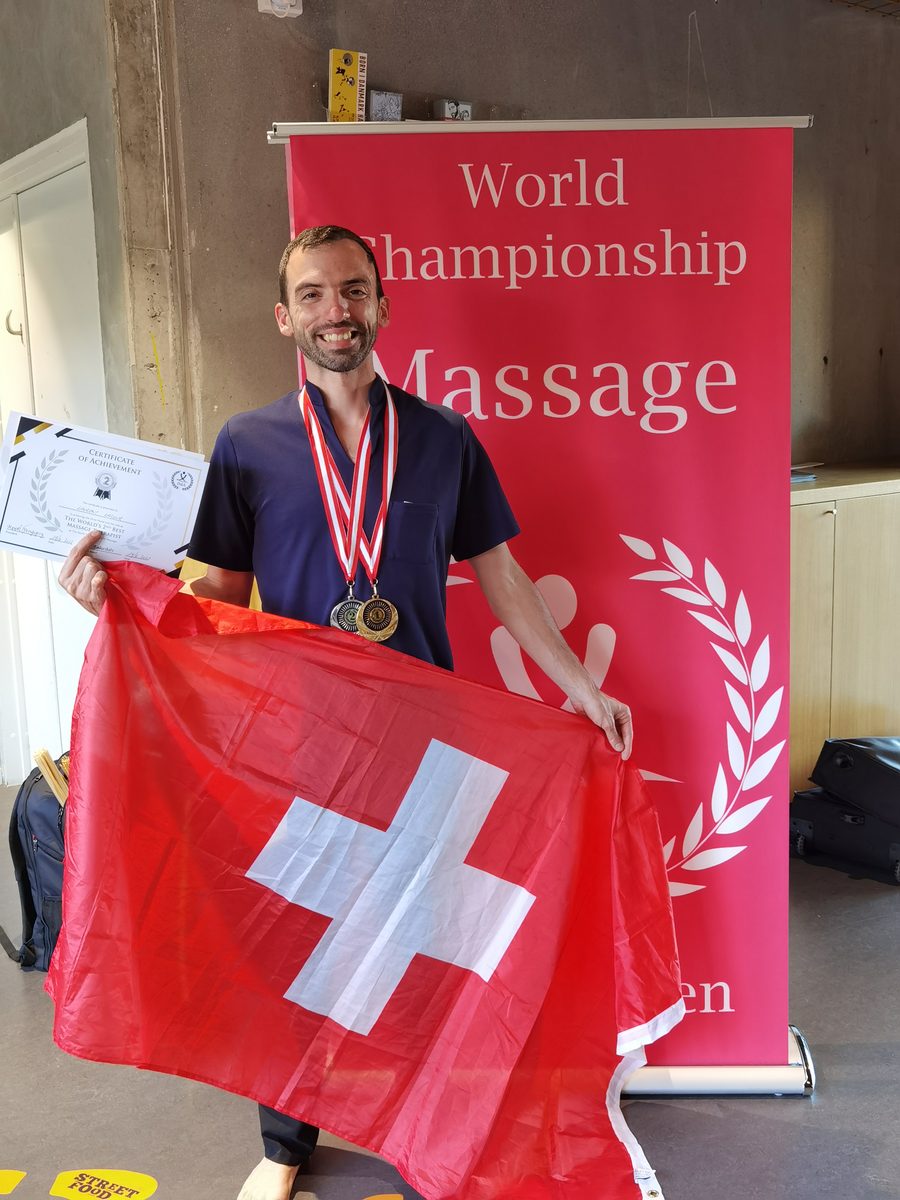 Laurent Lacour, massothérapeute à Genève, médaillé au Championnat du Monde de Massage 2022 à Copenhague, drapeau suisse à la main